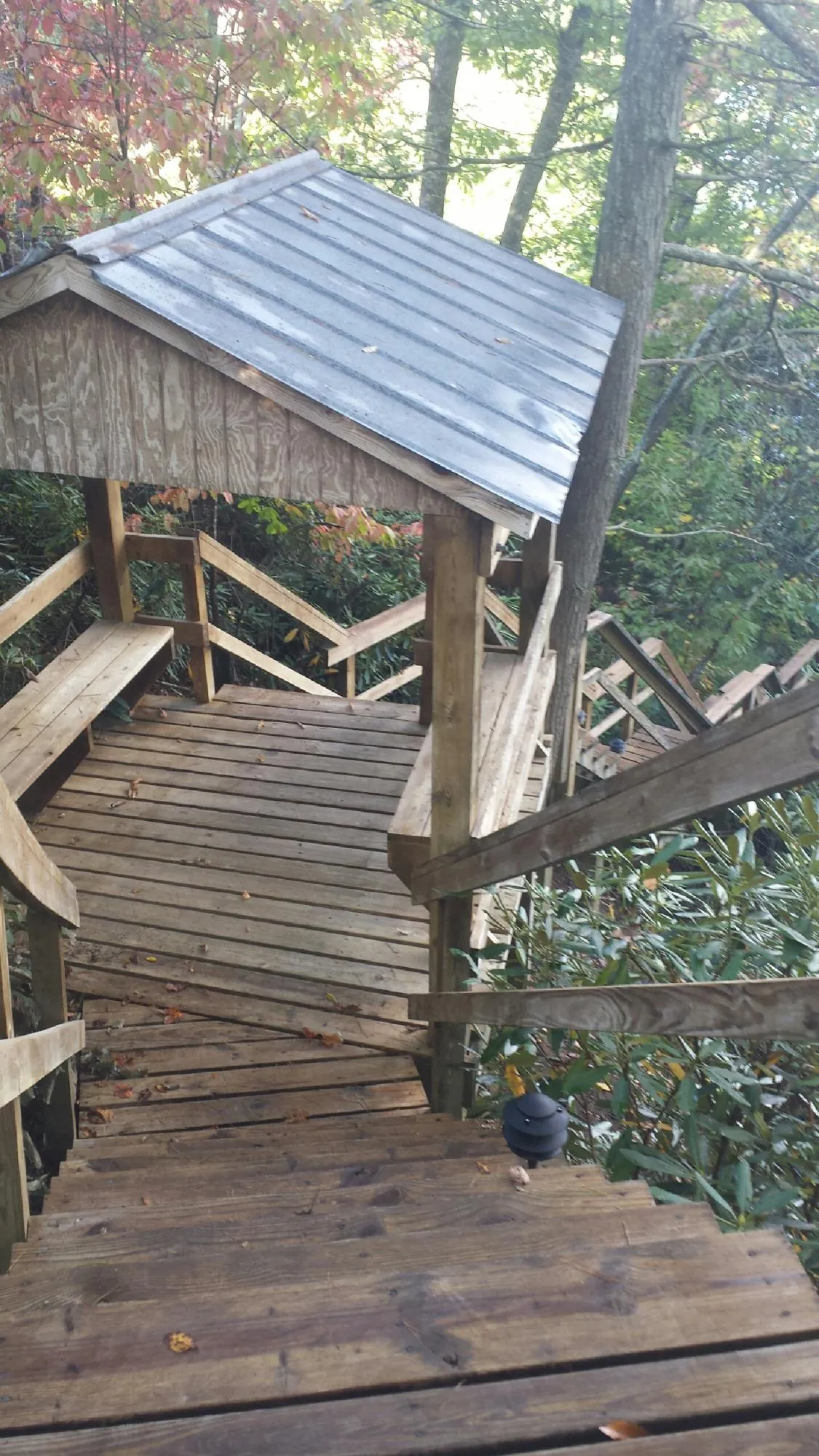 Metal roofed shelter over wooden steps on a wooded walkway — Skylight Repair & Installation work by our crew in Isle